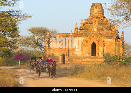 Touristen, die ein Pferd und Wagen fahren an Tempeln, Stupas in der Abendsonne in Bagan, Myanmar (Birma), Asien im Februar Stockfoto