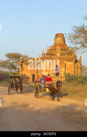 Touristen, die ein Pferd und Wagen fahren an Tempeln, Stupas in der Abendsonne in Bagan, Myanmar (Birma), Asien im Februar Stockfoto