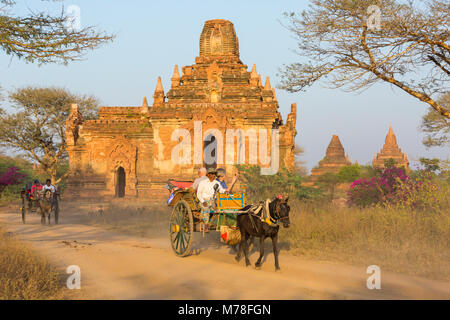 Touristen, die ein Pferd und Wagen fahren an Tempeln, Stupas in der Abendsonne in Bagan, Myanmar (Birma), Asien im Februar Stockfoto