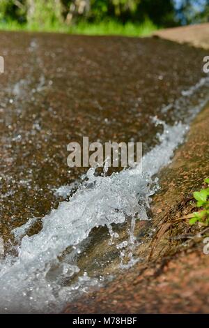 Wasserkaskaden über Aplins Wehr mit Mount Stuart im Hintergrund nach Stürme und Starkregen, Aplins Wehr, Townsville, Queensland, Australien Stockfoto