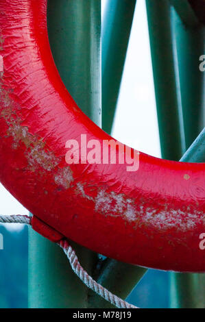 Alte, Rot, cracky Rettungsring close-up Hängen auf grün Metall Pier Stockfoto