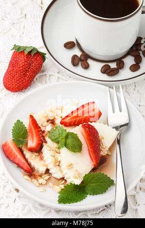 Gesundes Frühstück. Käse mit Müsli, Erdbeeren, Minze und Sirup. Selektiver Fokus Stockfoto