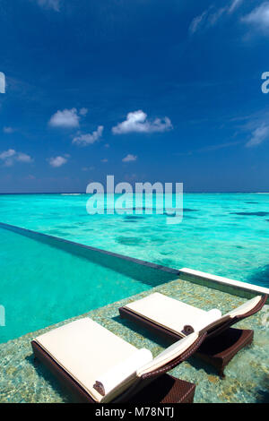 Die Liegestühle am Pool und tropischen Strand, Malediven, Indischer Ozean, Asien Stockfoto