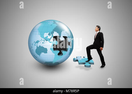 Geschäftsmann auf die Puzzle Globus. Stockfoto