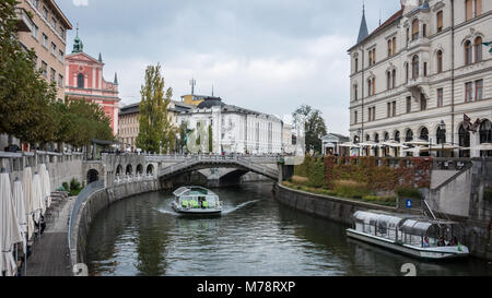 Touristenboot auf Fluss Ljubljanica unter den Drei Brücken, Altstadt, Ljubljana, Slowenien Stockfoto