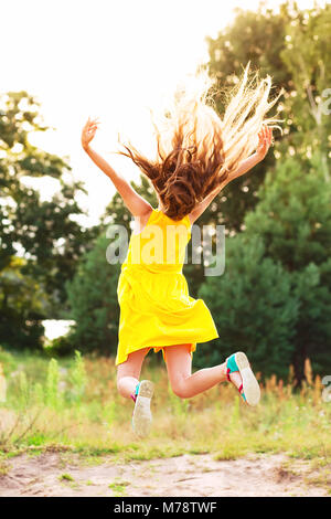 Schöne jugendlich Mädchen außerhalb springen im Sommer Sonnenuntergang Stockfoto