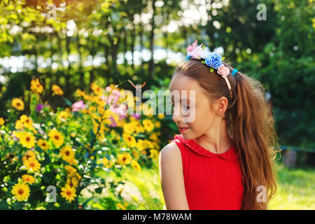 Cute teen Mädchen sitzt und Träumen im Garten in den warmen sonnigen Sommertag Stockfoto