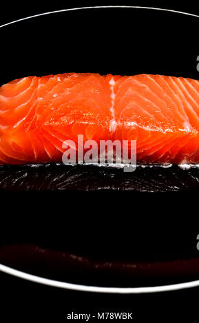 Roher Lachs Steak/Filet auf einer schwarzen Platte Stockfoto