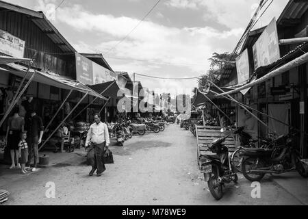 Die burmesische Mann zu Fuß durch pflanzliche und Mode stände im lokalen traditionellen asiatischen Nyaung U Markt Bagan Myanmar Birma, tragen lila longyi Stockfoto