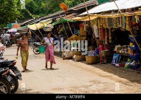 Zwei burmesische Frauen, Shopping in Nyaung U lokalen Markt, Leiter - Balancing ein Becken mit Lebensmitteln auf den Kopf in der Nähe von Bagan, Myanmar, Birma Asien Stockfoto