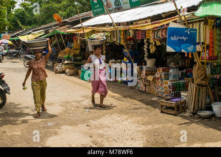 Zwei burmesische Frauen, Shopping in Nyaung U lokalen Markt, Leiter - Balancing ein Becken mit Lebensmitteln auf den Kopf in der Nähe von Bagan, Myanmar, Birma Asien Stockfoto