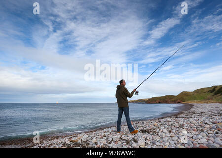 Mann angeln in der Nordsee aus der Schindeln auf neue Brighton & Hove Strand in Aberdeenshire, Schottland, Großbritannien Stockfoto