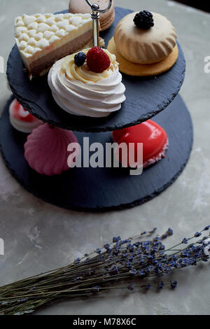 Kuchen auf dunklem Schiefer Etagenbett stehen. Desserts. Süße Tabelle Stockfoto