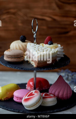 Kuchen auf dunklem Schiefer Etagenbett stehen. Desserts. Süße Tabelle Stockfoto