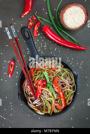 Buchweizen Soba Nudeln mit Karotten, Paprika, Zucchini, Frühlingszwiebeln und Sesam - ein traditionelles Gericht der asiatischen Küche. Vegetarisches Gericht. Selektive Stockfoto