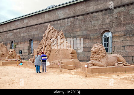 Leute schauen auf den Sand Skulpturen auf das Sandskulpturenfestival in der Nähe der Peter und Paul Festung Wand Stockfoto