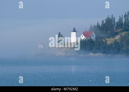 Verbrannten Mantel Hafen Leuchtturm der Swan Insel in Maine, ist von der Sonne beschienen, während es durch den Morgennebel bricht. Leuchtturm ist im Acadia re Stockfoto