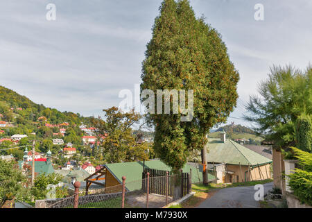 Schmale Straße mit Blick über die Stadt mit dem Kalvarienberg im Hintergrund. Banska Stiavnica, Slowakei. UNESCO-Weltkulturerbe. Stockfoto