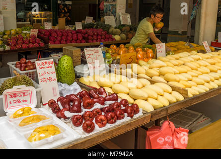 Ein Singaporean Frau Shopping für frisches Obst in einem Stall in einem Markt, Singapur. Stockfoto
