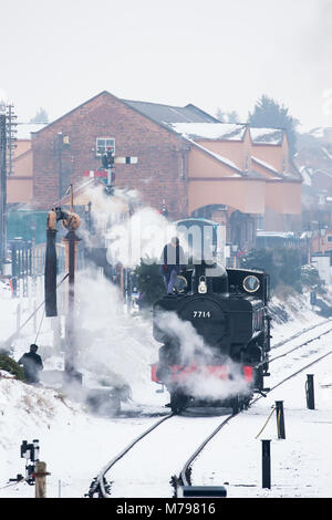 Portraitfotos: konserviertes UK Dampfmaschine 7714 puffing im Schnee in Kidderminster Severn Valley Railway Station. Morgen Vorbereitungen, Beginn des Tages. Stockfoto