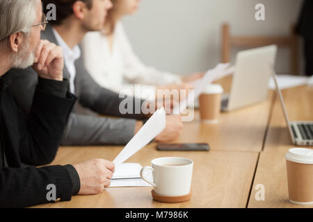 Aufmerksame ältere Unternehmer konzentriert sich auf das Hören in der Gruppe meeti Stockfoto