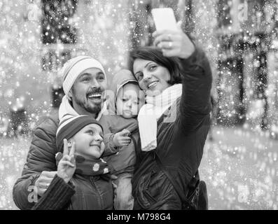 Gerne freundliche Familie mit zwei Kindern zu Fuß die Stadt und tun selfie im Herbst Stockfoto