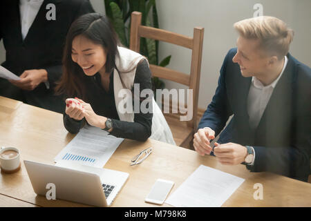 Attraktiven asiatischen Geschäftsfrau und kaukasischen Geschäftsmann laughin Stockfoto