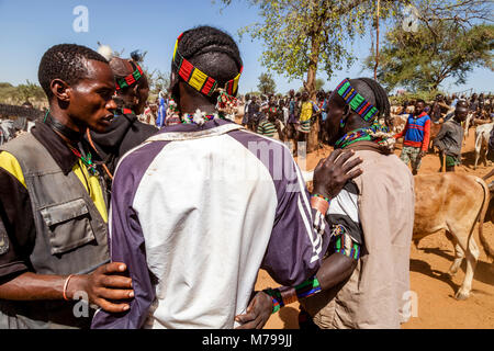 Junge Hamar Männer, Kauf und Verkauf von Vieh bei der wöchentlichen Stammes- Markt in Dimeka, Omo Valley, Äthiopien Stockfoto