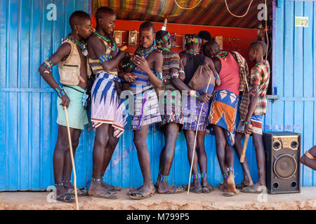 Junge Hamar Männern außerhalb ein Mobiltelefon (Handy) Shop während Ihrer wöchentlichen Besuch der Stammes- Markt in Dimeka, Omo Valley, Äthiopien Stockfoto