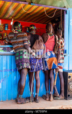 Junge Hamar Männern außerhalb ein Mobiltelefon (Handy) Shop während Ihrer wöchentlichen Besuch der Stammes- Markt in Dimeka, Omo Valley, Äthiopien Stockfoto