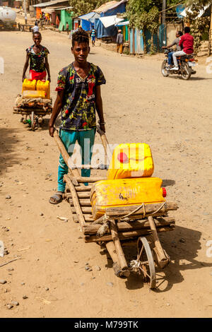 Lokalen Jungen Transportieren von Wasser in der Stadt Jinka, Omo Valley, Äthiopien Stockfoto