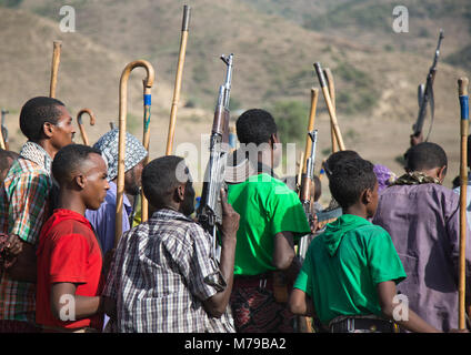 Oromo Männern und Jungen mit Stöcken, Stöcke und Waffen tanzen und fröhlich feiern eine Hochzeit, Oromo region, Sambate, Äthiopien Stockfoto