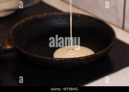 Pfannkuchenteig Backmischung aus einer Schüssel auf einen heißen elektrische Grillpfanne Küche leckere Frühstück Mahlzeit für eine Familie gegossen. Stockfoto