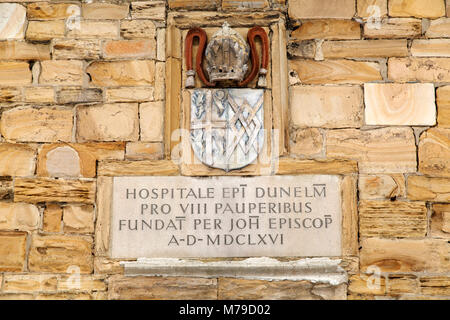 Inschrift und Wappen an der arme Schlucker-Krankenhaus in Durham, England. Das historische Gebäude stammt aus dem Jahre 1666 und steht im Palace Grün. Stockfoto