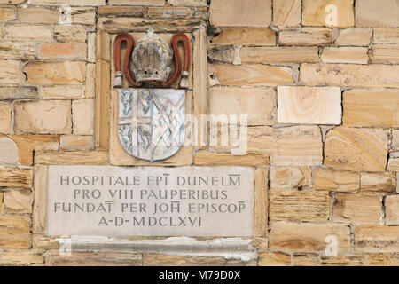 Inschrift und Wappen an der arme Schlucker-Krankenhaus in Durham, England. Das historische Gebäude stammt aus dem Jahre 1666 und steht im Palace Grün. Stockfoto