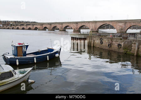 Boote auf dem Fluss Tweed in Berwick-upon-Tweed in England. Brücke Ende, eine niedrige steinerne Brücke, überquert den Fluss. Stockfoto