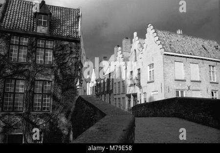 Peerdenbrug: Eine alte steinerne Brücke über den Kanal Groenerei am unteren Rand Peerdenstraat, Brugge, Belgien. Schwarz-weiß Film Foto Stockfoto