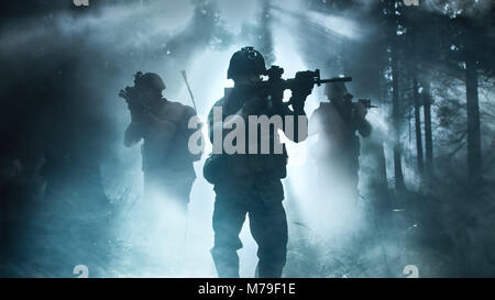 Silhouette der voll ausgestatteten Soldaten Bewegen durch Smokey Wald mit Gewehr bereit zu schießen. Aufklärung der militärischen Operation. Squad ist in Bewegung. Stockfoto