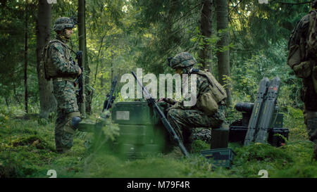 Militärische Inszenierung Base, Chief Army Engineer Sitzen auf den Kisten mit Munition verwendet Armee Grade Laptop Ausgestellt von militärisch-industrielle Komplex. Stockfoto