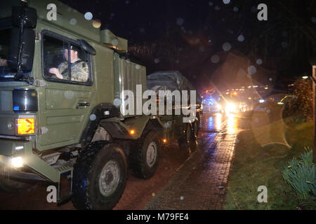 Ein Konvoi von Polizei und Militär Fahrzeuge verlassen Salisbury District Hospital als Polizei Auto weggenommen, wird als Truppen eingesetzt. Polizei Antasten der Nerv agent Vergiftung der Spion Sergei Skripal und seiner Tochter zu helfen. Stockfoto