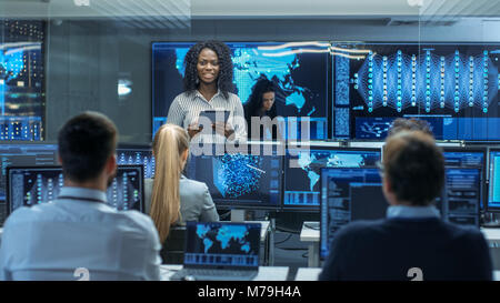 Chief Project Engineer berät Tablet Computer und hält Briefing für ein Team von Wissenschaftlern, die Gebäude Machine Learning System. Stockfoto