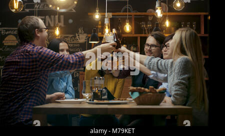 Vielfältige Gruppe von Freunde Feiern mit einem Toast und Clink angehoben Gläser mit verschiedenen Getränken in der Feier. Schöne junge Leute haben Spaß Stockfoto