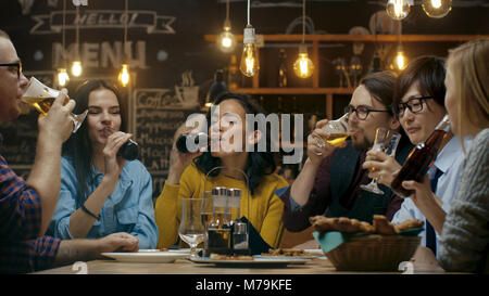 Vielfältige Gruppe von Freunde Feiern mit einem Toast und Clink angehoben Gläser mit verschiedenen Getränken in der Feier. Schöne junge Leute haben Spaß Stockfoto