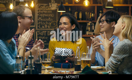 In der Bar/Restaurant präsentiert die besten Freunde zu einem wunderschönen Hispanic Frau geben, wünschen Ihr alles Gute zum Geburtstag. Jeder ist glücklich. Stockfoto