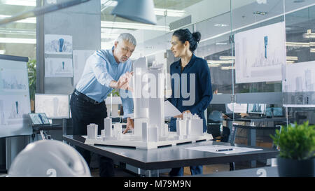 Chief männlichen Architekten und Ingenieurin mit städtischen Gebäude Modell. Helle Leute Arbeit als Stadtplaner. Stockfoto