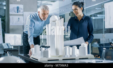 In der architektonischen Präsidium zwei professionelle Ingenieure arbeiten an einem Modell eines Stadtteils. Stadtplaner arbeiten auf ein funktionales Gebäude Modell. Stockfoto