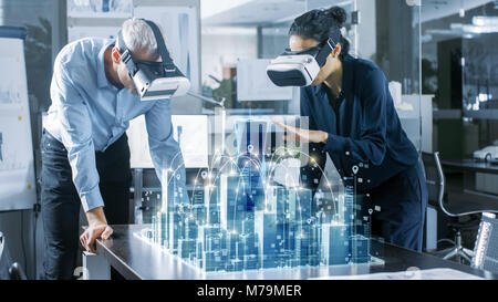 Männlichen und Weiblichen Architekten tragen Augmented Reality Headsets Arbeiten mit 3D-Stadtmodell. High Tech Office Professional Menschen Virtuelle Realität Modell Stockfoto