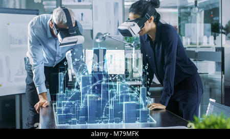 Männlichen und Weiblichen Architekten tragen Augmented Reality Headsets Arbeiten mit 3D-Stadtmodell. High Tech Office Professional Menschen Virtuelle Realität Modell Stockfoto