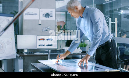 Erfahrene Automotive Designer arbeitet mit digitaler Anzeige Grafiktablett Touschreen Tabelle, Zeichnung Skizze eines neuen Prototyp. Stockfoto