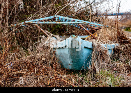 Ein verfallenes blau Boot legt in der Unkräuter neben der Sagami River in der Nähe von Ebina aufgegeben, in Kanagawa, Japan. Stockfoto